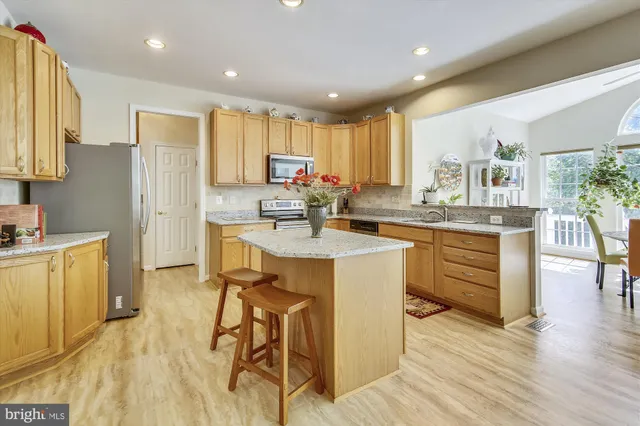 a kitchen with kitchen island granite countertop a sink counter and chairs