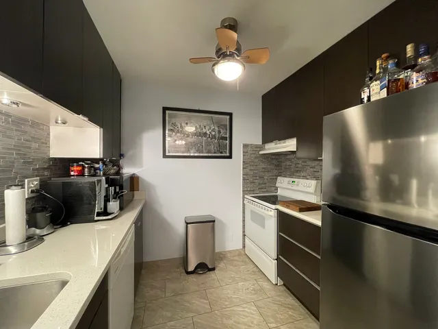 a view of a dining room with furniture and a chandelier fan