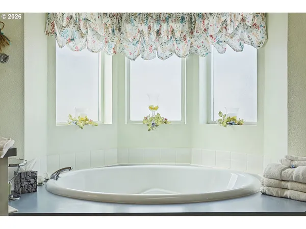 a bath tub sitting next to a white curtain