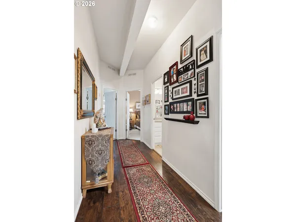 a hallway with a large mirror and a wooden floor