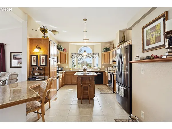 a view of a dining room and livingroom with furniture wooden floor a chandelier