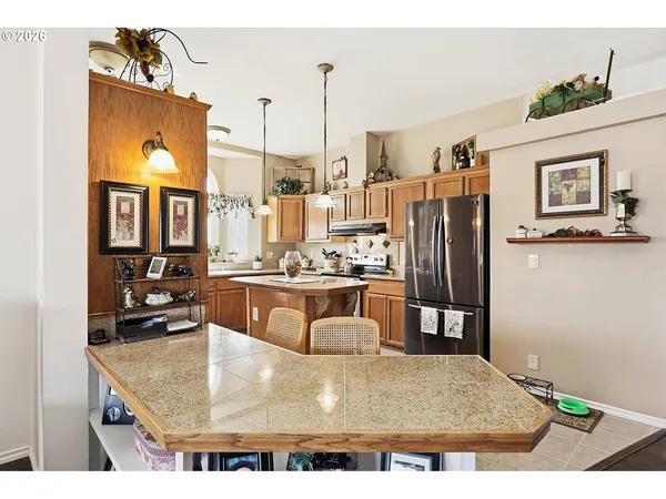 a kitchen with refrigerator and table