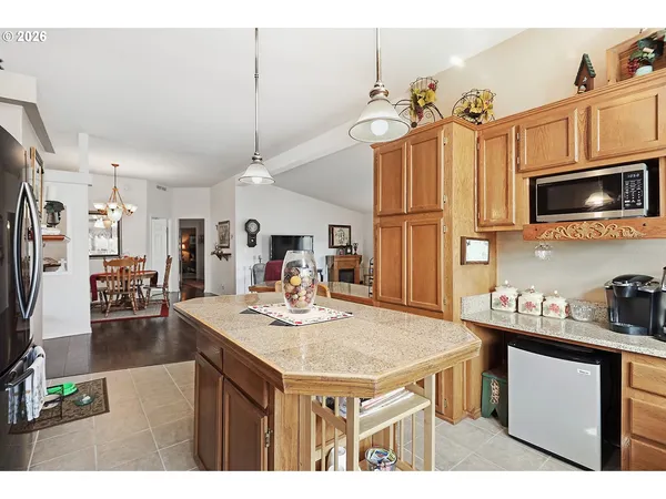 a kitchen with kitchen island granite countertop a sink cabinets and stainless steel appliances