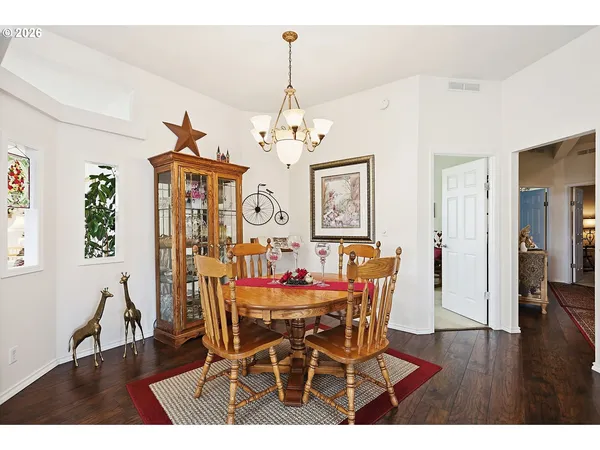 a dining room with furniture a chandelier and wooden floor