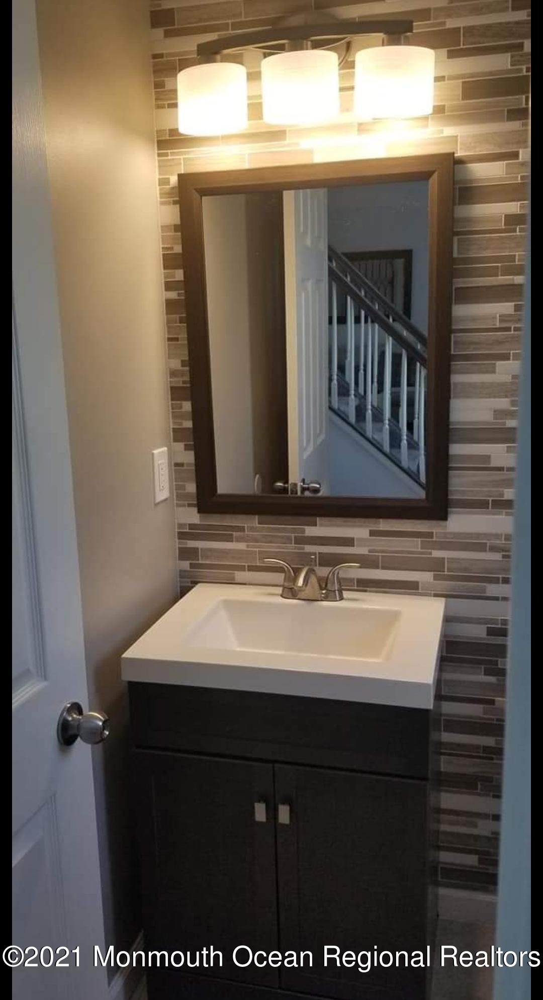 128 Captain Road Manahawkin, NJ 08050 - Photo 19 of 20 a bathroom with a sink and a mirror