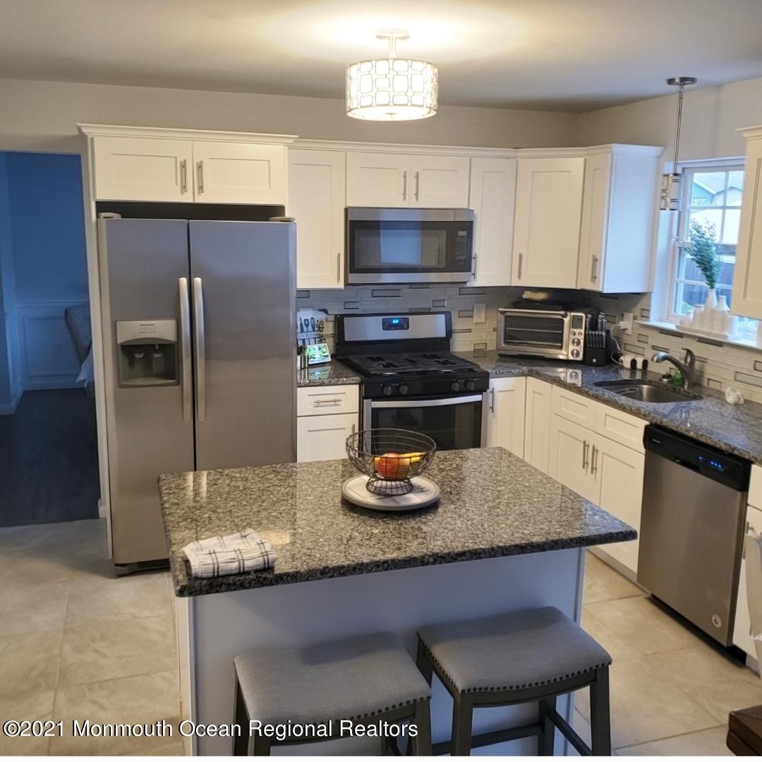 128 Captain Road Manahawkin, NJ 08050 - Photo 3 of 20 a kitchen with granite countertop a sink appliances and cabinets