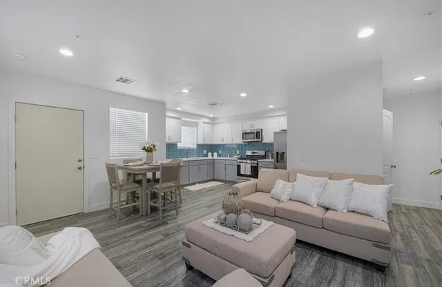 a living room with furniture kitchen view and a dining table
