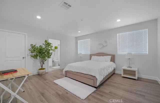 a bedroom with a bed and a potted plant