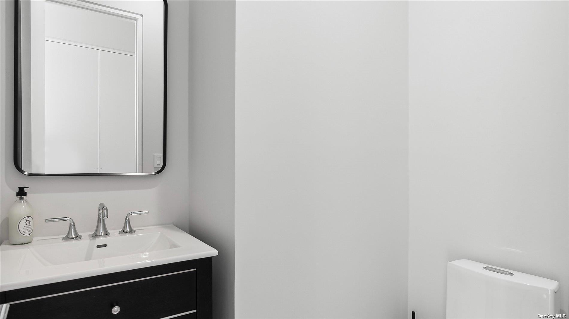 314 Dune Road Westhampton Beach, NY 11978 - Photo 5 of 18 a bathroom with a sink and a mirror