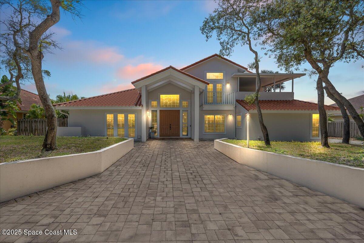a view of a house with a yard and large tree