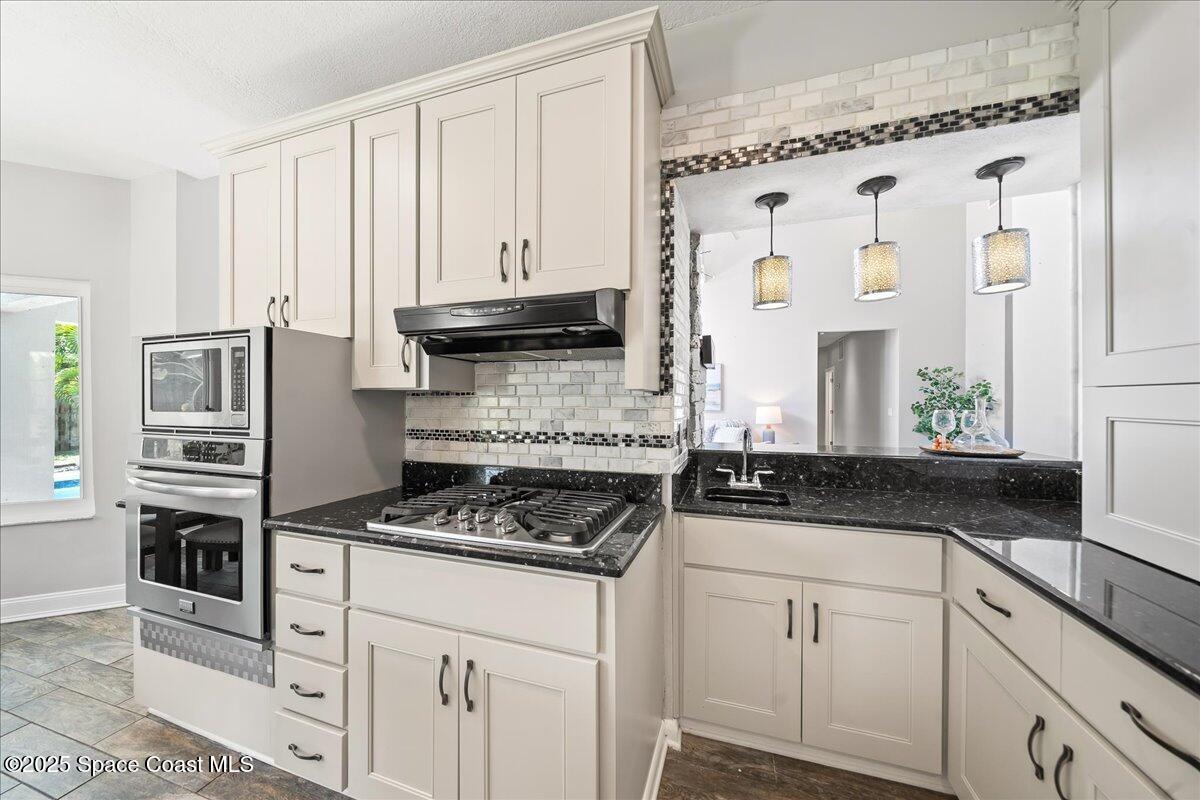 505 Sanderling Drive Indialantic, FL 32903 - Photo 16 of 63 a kitchen with stainless steel appliances granite countertop a stove a sink and a white cabinets