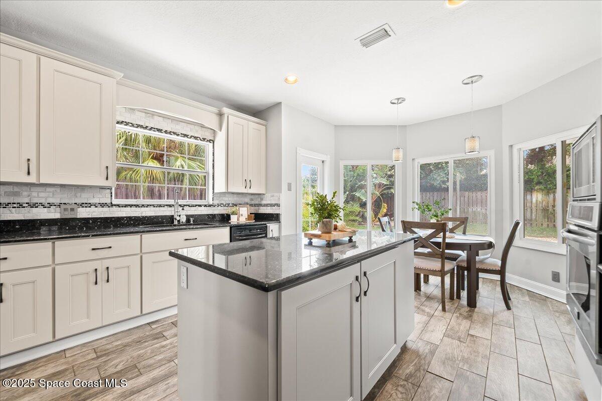 505 Sanderling Drive Indialantic, FL 32903 - Photo 17 of 63 a kitchen with sink a window and chairs