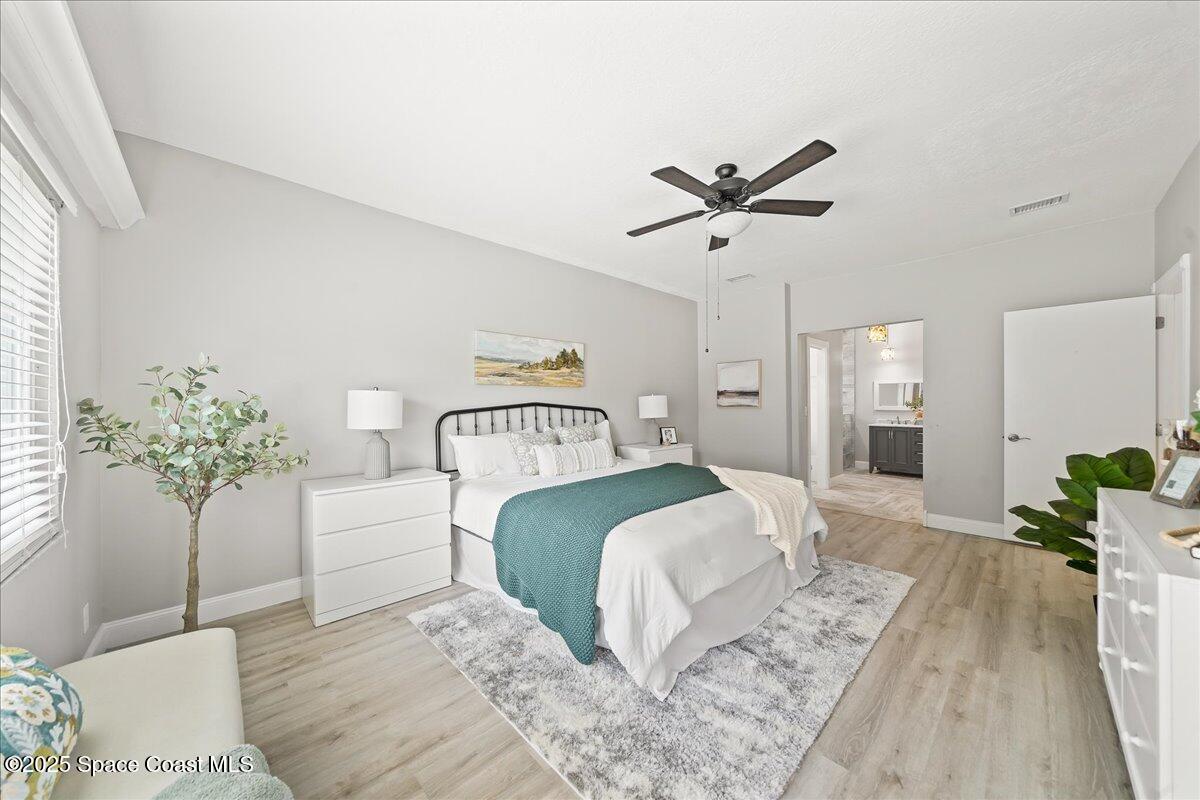 505 Sanderling Drive Indialantic, FL 32903 - Photo 20 of 63 a bedroom with a large bed and a chandelier