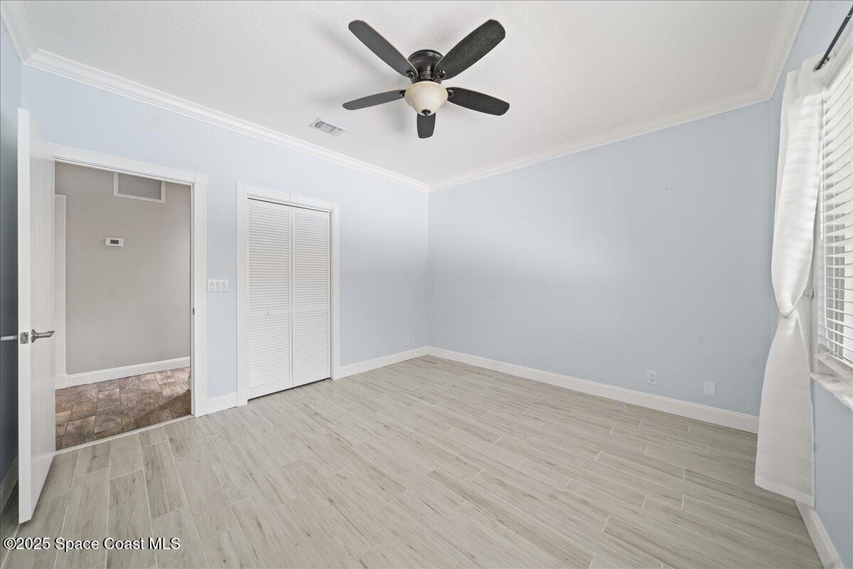 505 Sanderling Drive Indialantic, FL 32903 - Photo 25 of 63 an empty room with wooden floor and ceiling fan