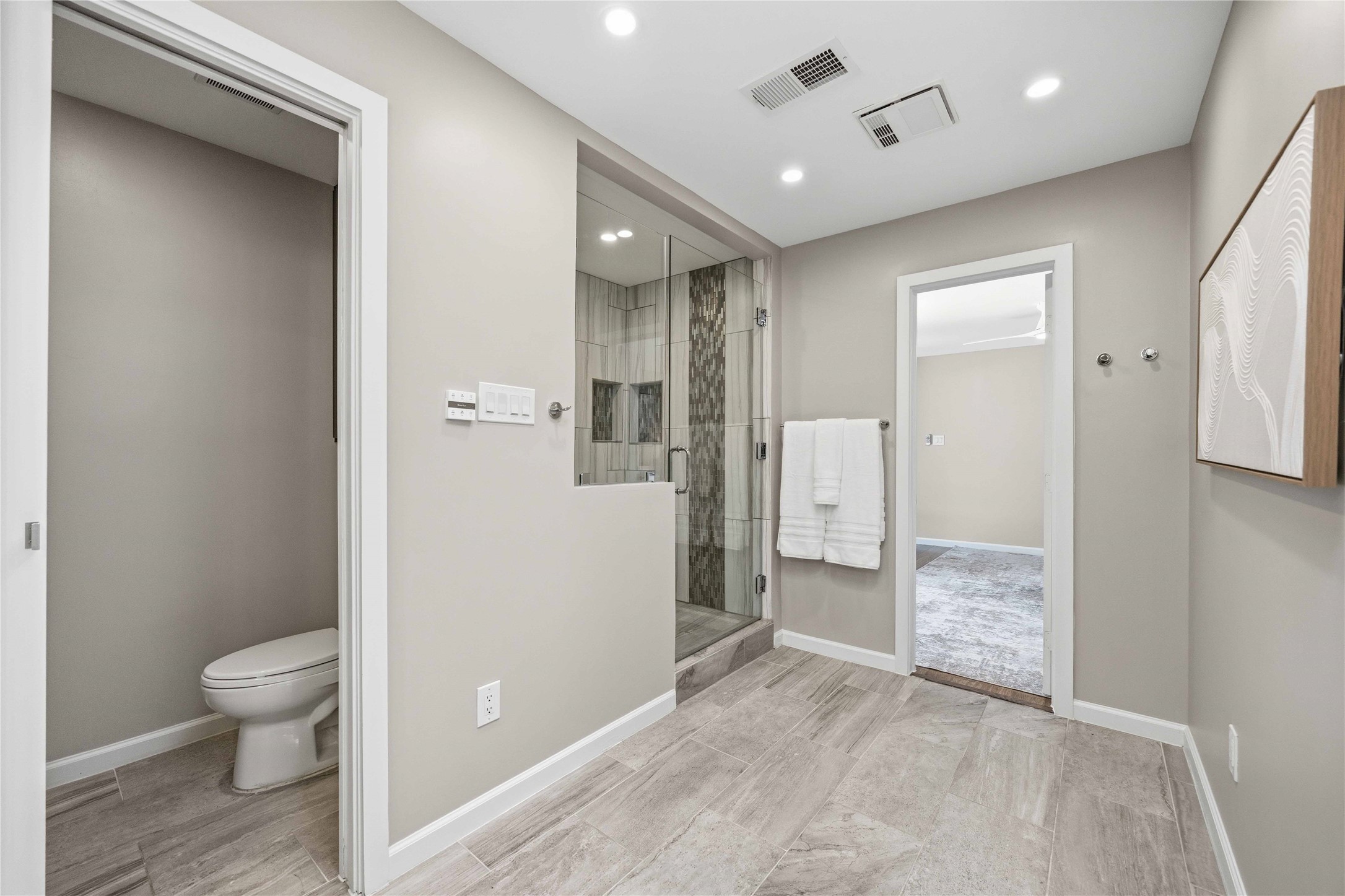 619 Rancho Bauer Drive Houston, TX 77079 - Photo 33 of 46 Spa-inspired primary bathroom featuring custom-made cabinetry, a spacious walk-in shower, skylights that bathe the space in natural light, and a private water closet