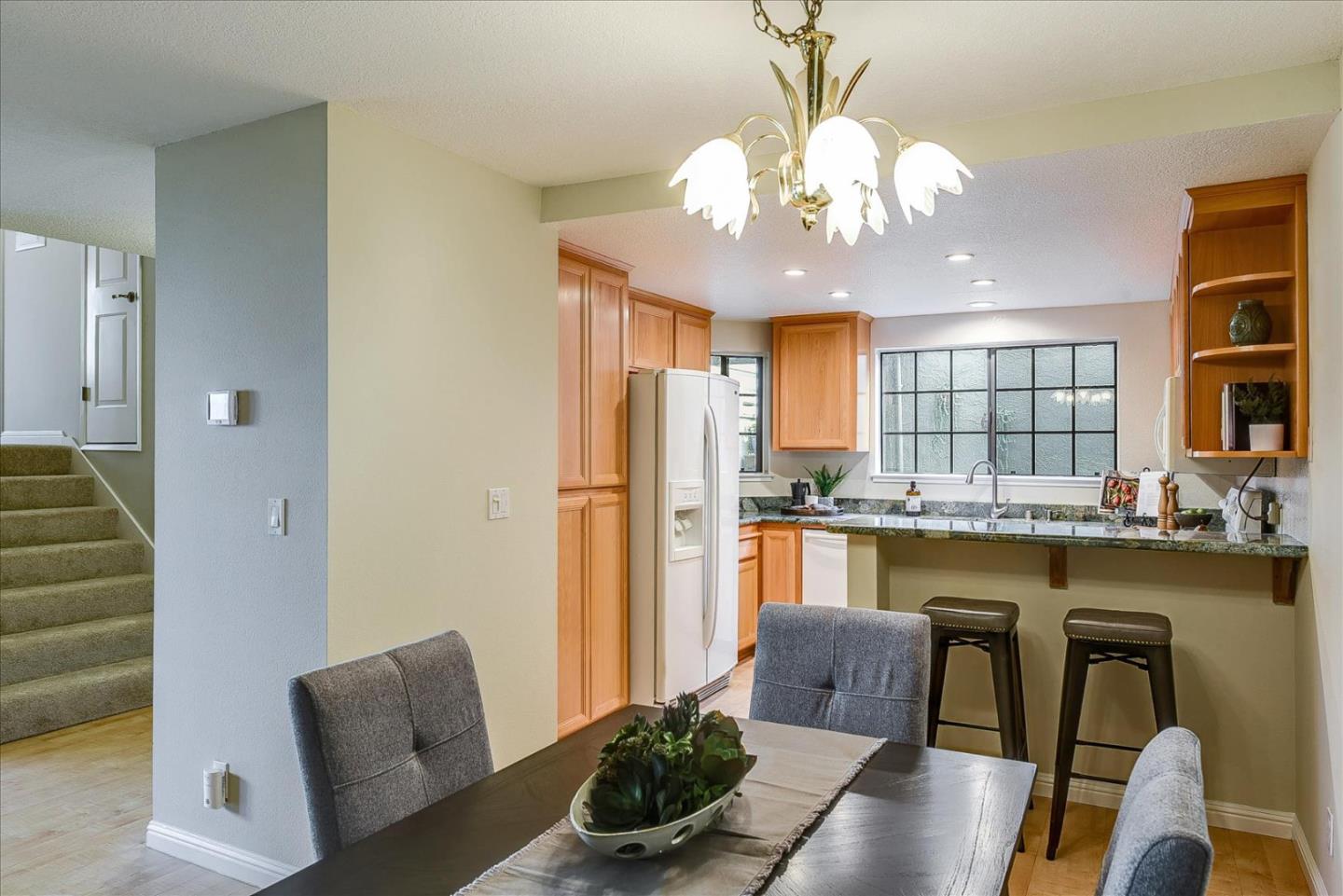 3120 Heather Ridge Drive San Jose, CA 95136 - Photo 11 of 25 a kitchen with stainless steel appliances granite countertop a dining table chairs and chandelier