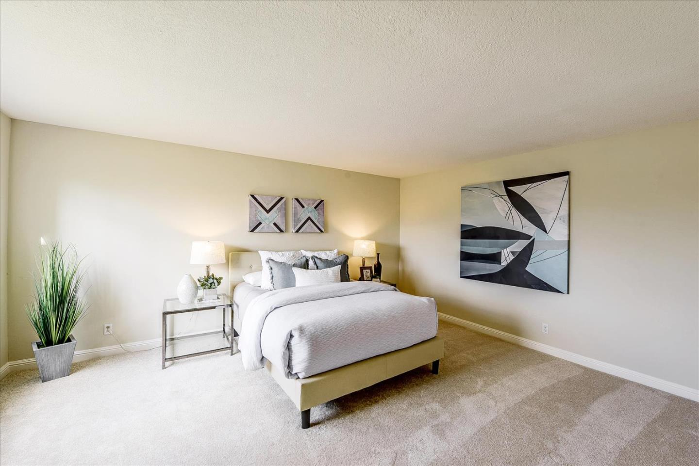 3120 Heather Ridge Drive San Jose, CA 95136 - Photo 18 of 25 a bedroom with a bed a painting on the wall and a potted plant