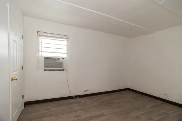 a view of a small space with wooden floor and a window