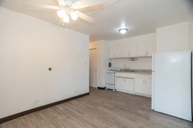 a kitchen with granite countertop white cabinets and white appliances