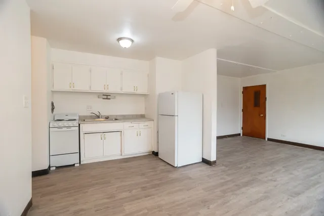 a kitchen with white cabinets and sink