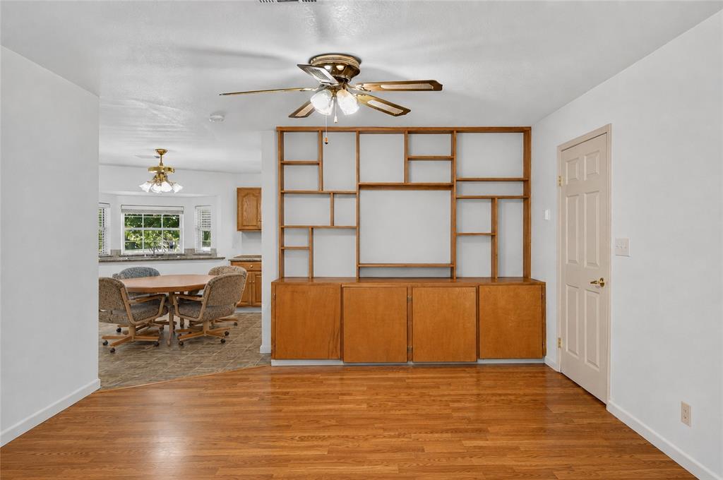 1612 Whitemound Road Sherman, TX 75090 - Photo 5 of 24 Hardwood-style flooring throughout, built-in shelving with lower cabinetry, and a ceiling fan with integrated lighting - Virtually Cleared