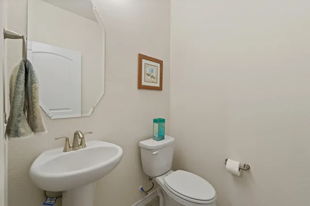 a bathroom with a sink a toilet and a mirror