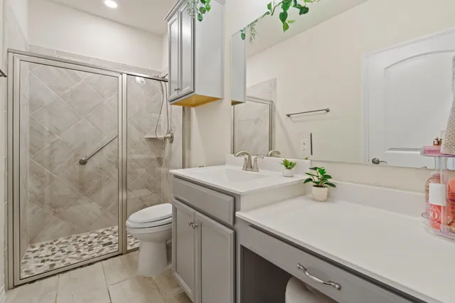 a bathroom with a sink a toilet and shower