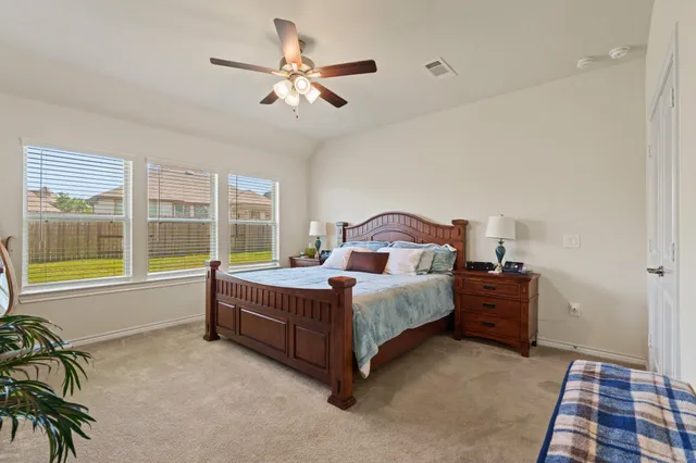 a spacious bedroom with a bed and a large window
