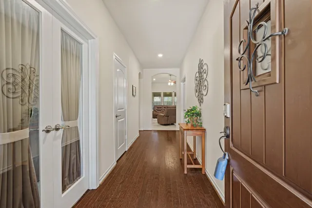 a view of a hallway with wooden floor and staircase