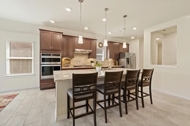 a large kitchen with a table and chairs