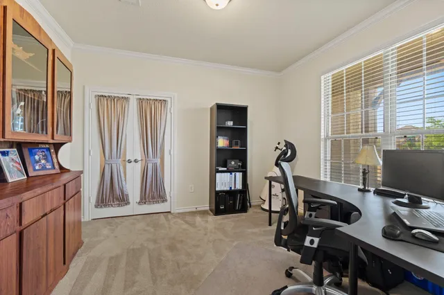 a view of a workspace with furniture and a window