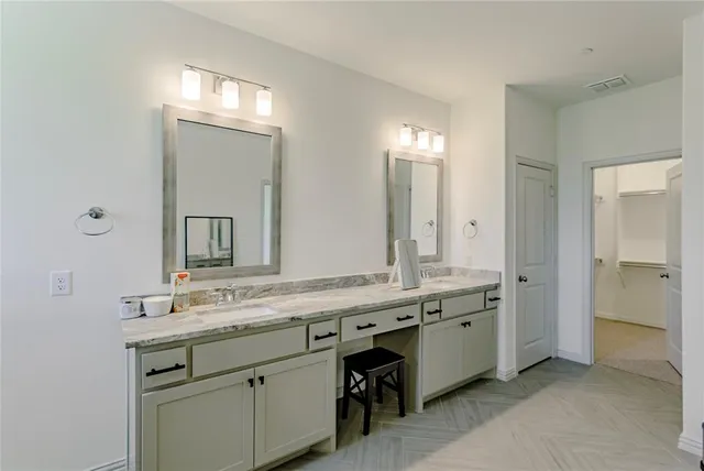 a spacious bathroom with double sink and a mirror