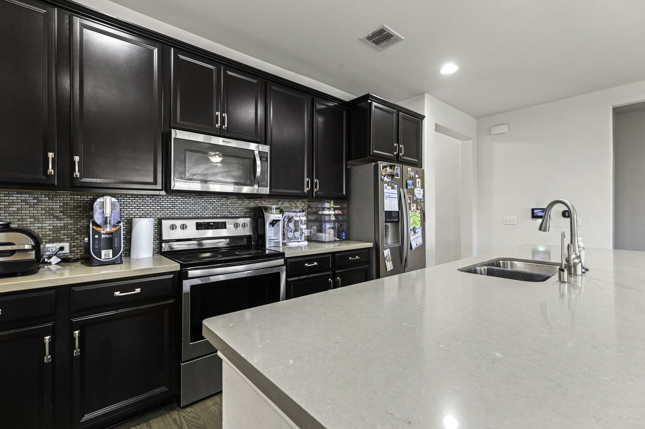 3116 Bragg Place Pflugerville, TX 78660 - Photo 13 of 29 a kitchen with stainless steel appliances a sink stove and refrigerator
