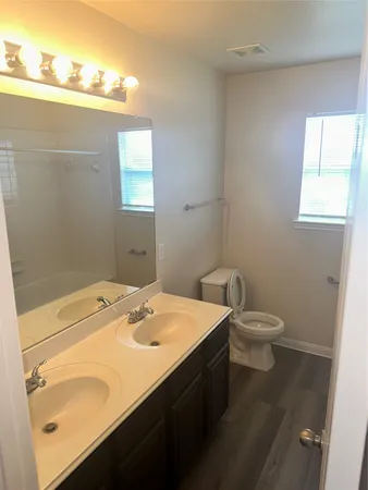 a bathroom with a sink a toilet and a window