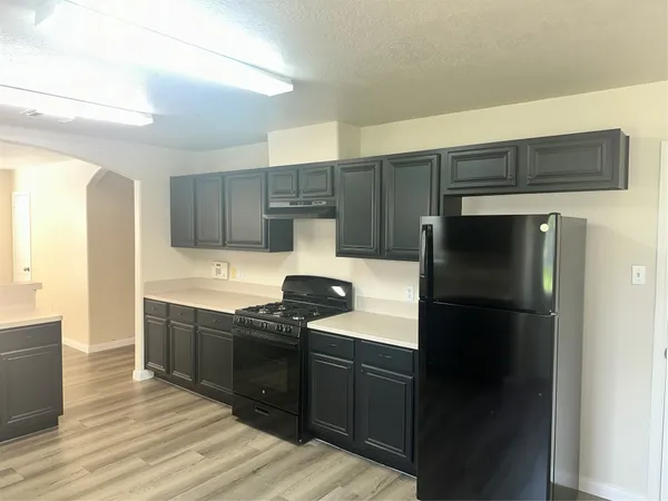 a kitchen with stainless steel appliances granite countertop a refrigerator and a stove top oven