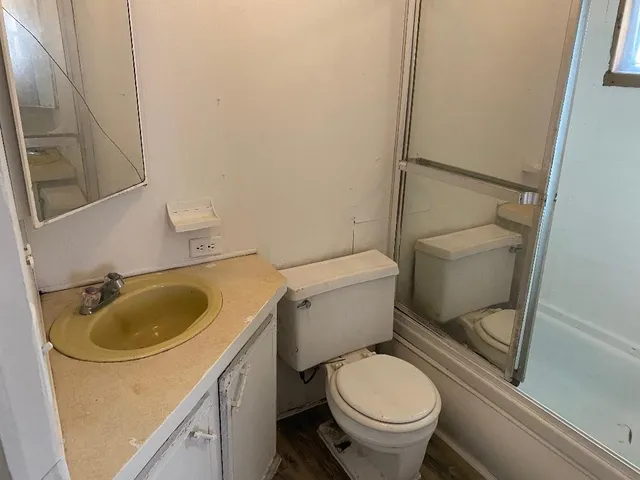 a bathroom with a sink toilet and a mirror