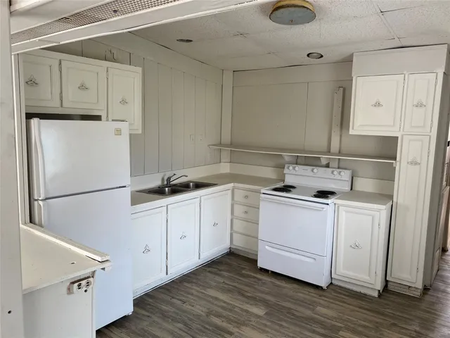 a kitchen with a refrigerator sink stove and cabinets