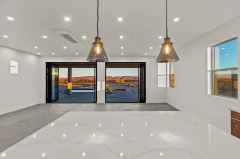 a view of kitchen with stainless steel appliances kitchen island a stove a sink a refrigerator and a fireplace
