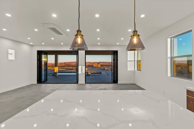 a view of kitchen with stainless steel appliances kitchen island a stove a sink a refrigerator and a fireplace