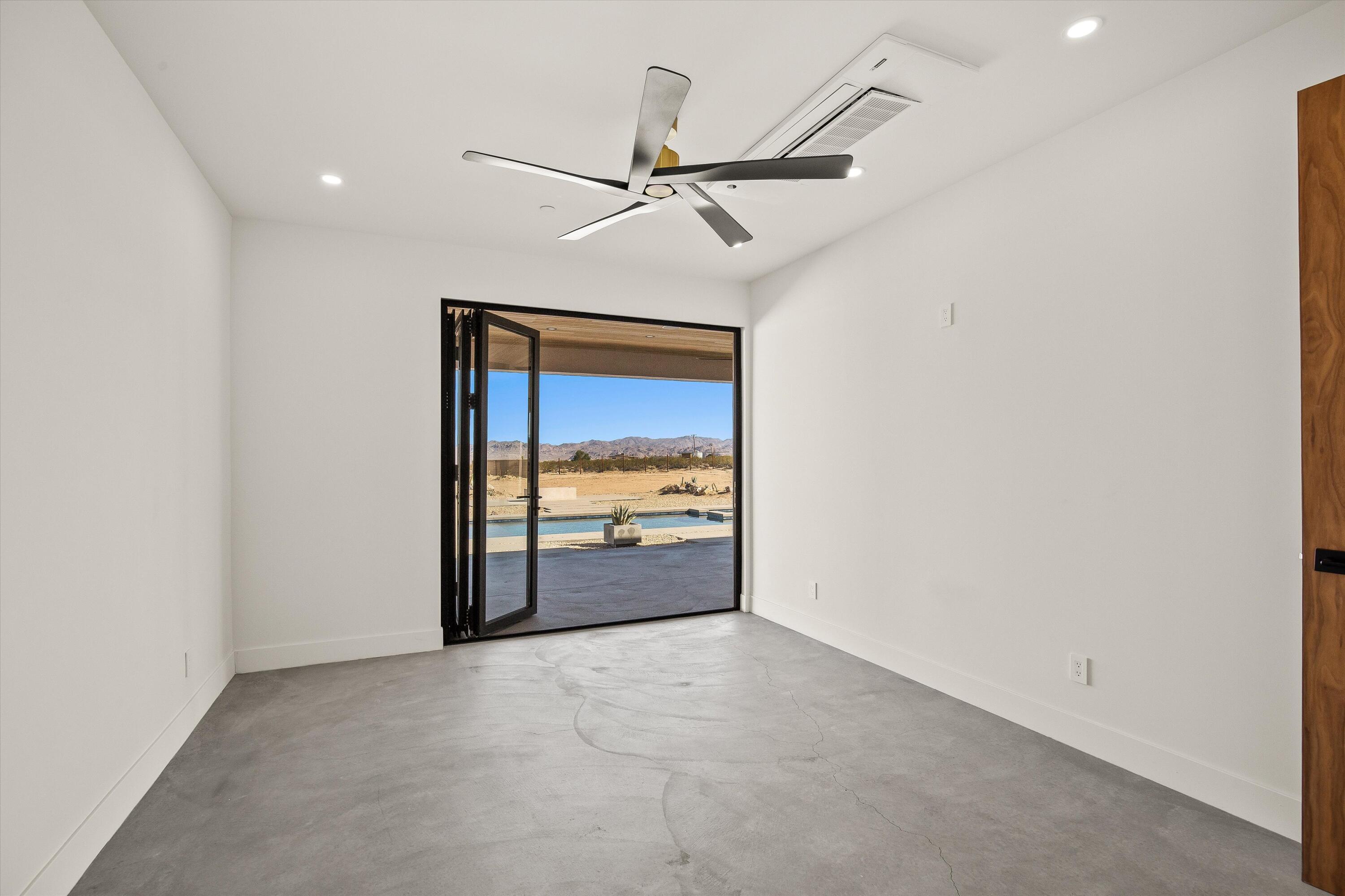 1925 Border Avenue Joshua Tree, CA 92252 - Photo 37 of 60 an empty room with a ceiling fan and a window