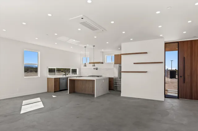 a large white kitchen with lots of counter top space and stainless steel appliances
