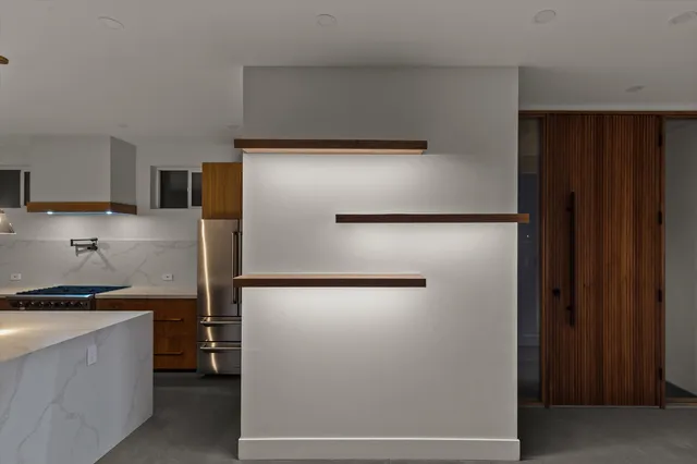 a kitchen with a refrigerator and a stove top oven