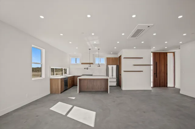 a kitchen with stainless steel appliances a sink a stove a refrigerator and cabinets