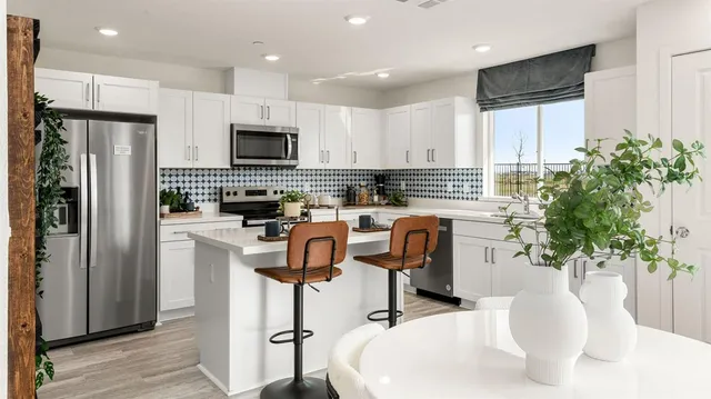 a kitchen with stainless steel appliances kitchen island granite countertop a refrigerator a stove a sink a microwave and cabinets