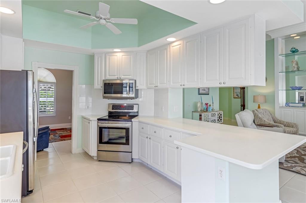 3794 Whidbey Way Naples, FL 34119 - Photo 11 of 46 a kitchen with stainless steel appliances white cabinets and a sink