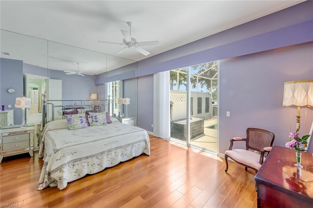 3794 Whidbey Way Naples, FL 34119 - Photo 17 of 46 a bedroom with a bed wooden floor and lamp