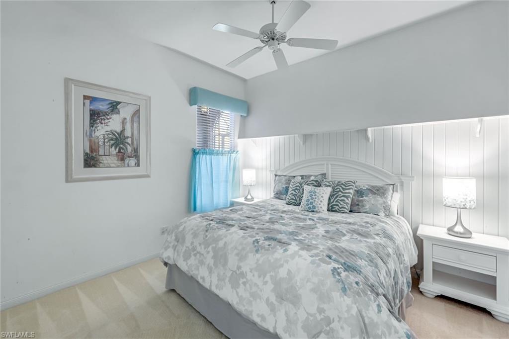 3794 Whidbey Way Naples, FL 34119 - Photo 21 of 46 a bedroom with a large bed and a chandelier