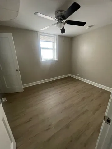 a view of a room with wooden floor and ceiling fan