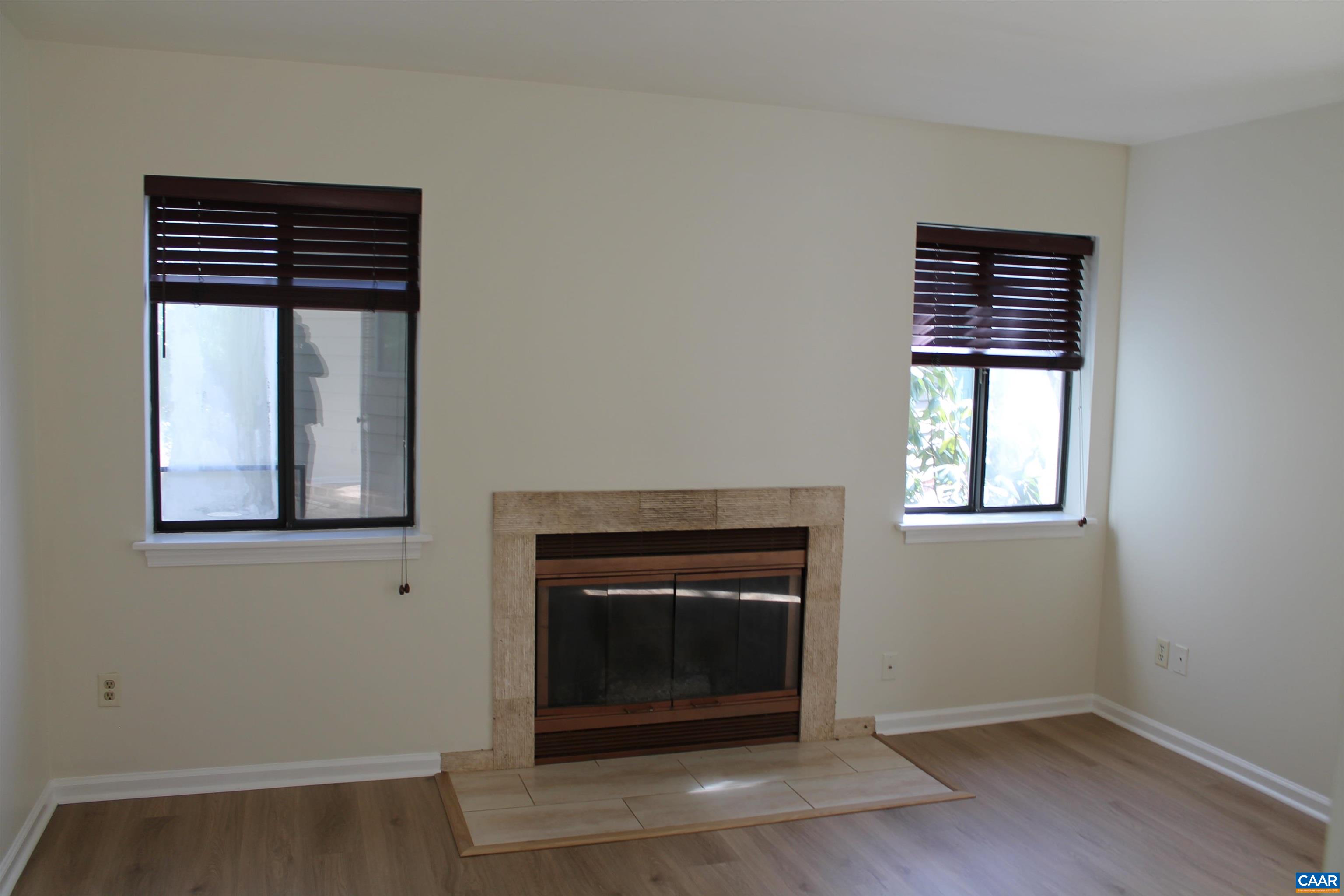 118 Mill Creek Drive Charlottesville, VA 22902 - Photo 3 of 30 a living room with a fireplace and wooden floor