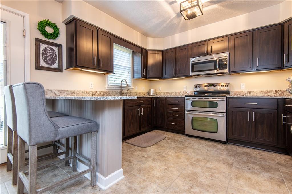 25 Stinedurf Road West Middlesex, PA 16159 - Photo 9 of 25 LARGER KITCHEN VIEW, DEPICTING COUNTER TOP & BAR STOOLS, NEUTRAL TONE FLOORING. SO STYLISH!